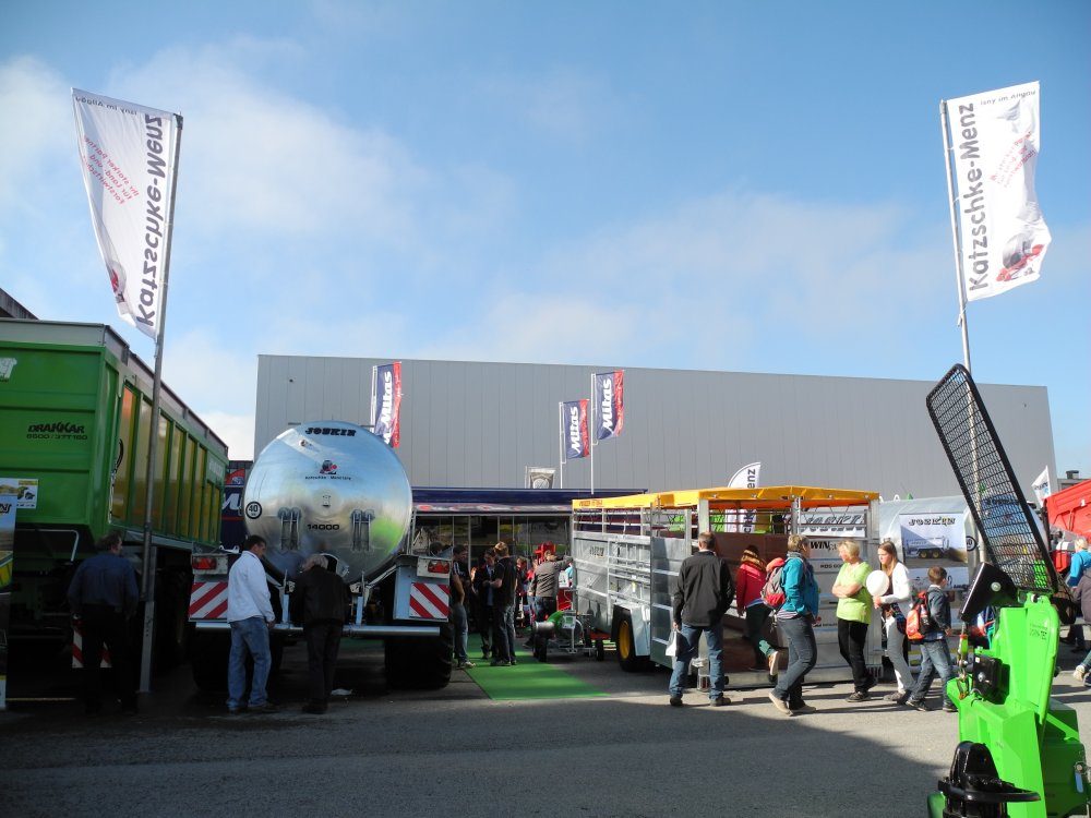 Blick über den Messestand mit JOSKIN-Güllefass, Anhängern und Fahnen von Katzschke-Menz