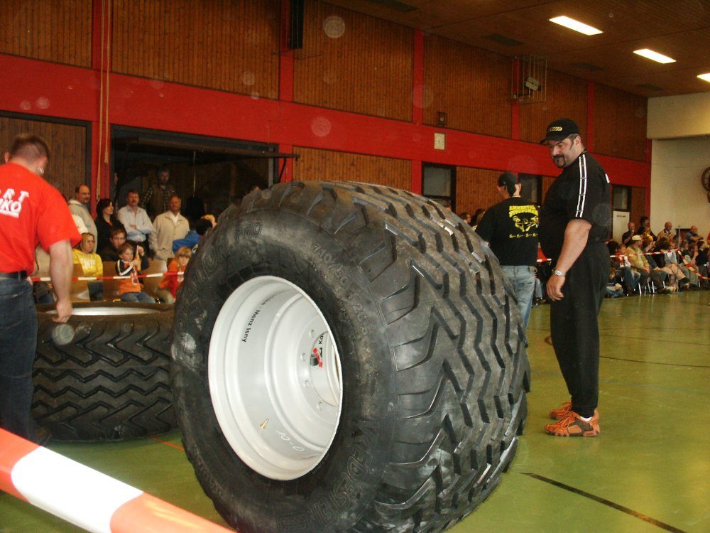 Großer Reifen mit silberner Felge in der Wettkampfhalle