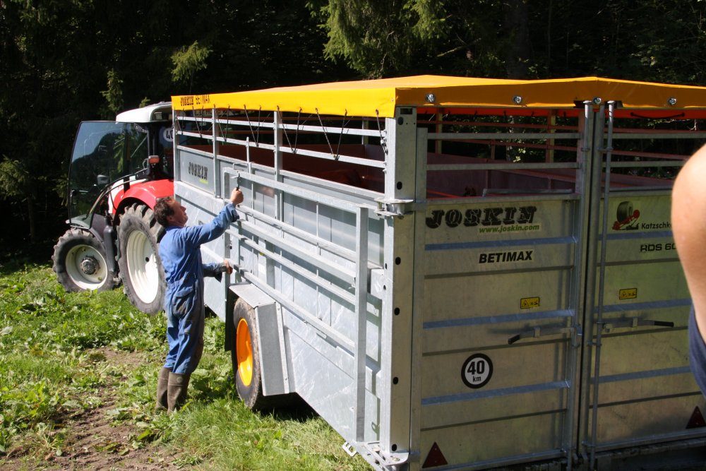 JOSKIN-Viehanhänger BETIMAX am Traktor beim Schließen der Tür